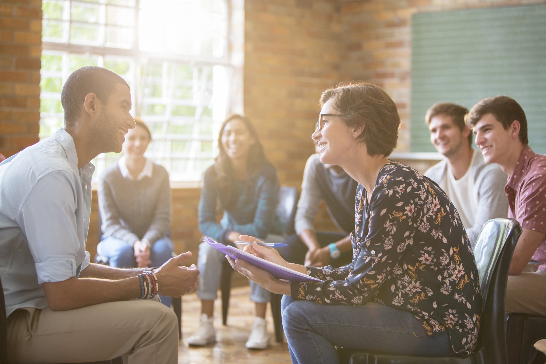 A counsellor leading a group conversation with young people
